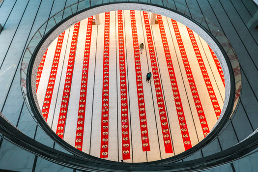 Dhaka Bangladesh 19 March 2025 View of a vibrant red and white patterned floor seen from a high circular vantage point with two distant figures. Dhaka Bangladesh 19 March 2025 View of a vibrant red and white patterned floor seen from a high circular vantage point with two distant figures.