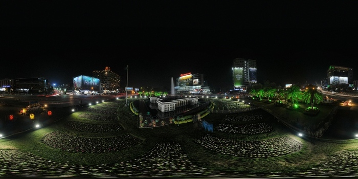 Lahore Pakistan 22 March 2023 Aerial view of Liberty Chowk at night featuring illuminated gardens a central fountain and surrounding city buildings with bright billboards.