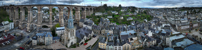 Aerial view of Eglise Saint Melaine de Morlaix and the massive stone viaduct surrounded by historic rooftops and urban architecture under a cloudy sky Morlaix Bretagne France. Aerial view of Eglise Saint Melaine de Morlaix and the massive stone viaduct surrounded by historic rooftops and urban architecture under a cloudy sky Morlaix Bretagne France.