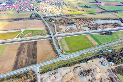 Aerial view of Buttenheim with residential houses agricultural fields and a major road intersection near an industrial site in Buttenheim Bavaria Germany. Aerial view of Buttenheim with residential houses agricultural fields and a major road intersection near an industrial site in Buttenheim Bavaria Germany.