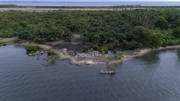 Aerial view of historic ruins on the shoreline surrounded by lush tropical vegetation and palm trees in Badagry Lagos Nigeria. Aerial view of historic ruins on the shoreline surrounded by lush tropical vegetation and palm trees in Badagry Lagos Nigeria.