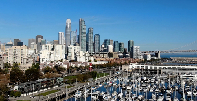Aerial view of Salesforce Tower and the San Francisco skyline above a marina filled with boats under a clear blue sky in San Francisco California United States. Aerial view of Salesforce Tower and the San Francisco skyline above a marina filled with boats under a clear blue sky in San Francisco California United States.