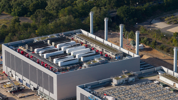 Aerial view of Data4 Hanau data center with cooling units on the roof surrounded by trees and industrial infrastructure in Hanau Hessen Germany. Aerial view of Data4 Hanau data center with cooling units on the roof surrounded by trees and industrial infrastructure in Hanau Hessen Germany.