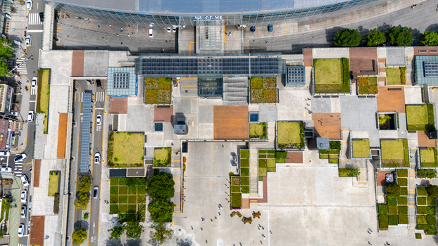Aerial view of Busan station featuring a modern plaza with geometric green roof sections pedestrian walkways and surrounding urban streets with traffic in Busan Busan South Korea. Aerial view of Busan station featuring a modern plaza with geometric green roof sections pedestrian walkways and surrounding urban streets with traffic in Busan Busan South Korea.