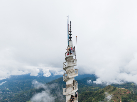 Gampola Sri Lanka 22 February 2026 Aerial view of Ambuluwawa Tower with its unique spiral staircase and tourists on the balcony overlooking misty green hills and clouds. Gampola Sri Lanka 22 February 2026 Aerial view of Ambuluwawa Tower with its unique spiral staircase and tourists on the balcony overlooking misty green hills and clouds.