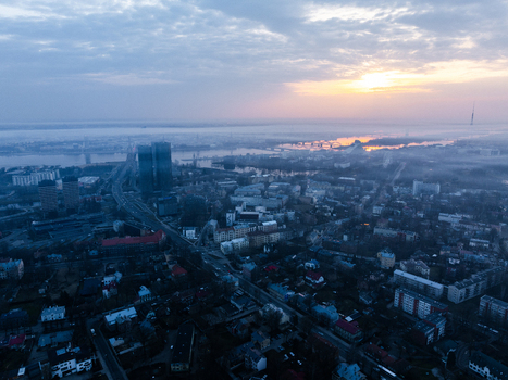 Aerial view of the city of Riga at sunrise with the Daugava River bridges and urban architecture shrouded in morning mist under a soft sky in Riga Latvia. Aerial view of the city of Riga at sunrise with the Daugava River bridges and urban architecture shrouded in morning mist under a soft sky in Riga Latvia.
