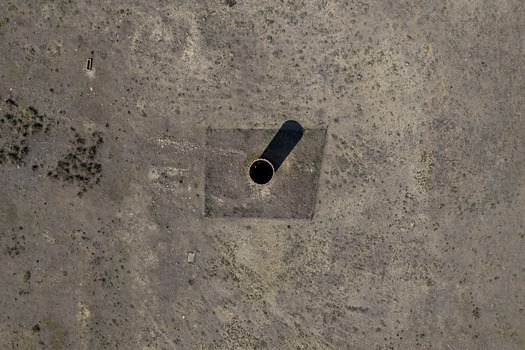 Aerial view of a circular mine shaft structure set in a dry arid landscape in Golden Colorado United States.