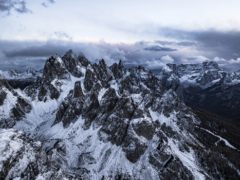 Aerial view of Cadini di Misurina Dolomites during twilight sky their dark forms contrasting with the soft ethereal glow of the clouds above Auronzo di Cadore Veneto Italy. Aerial view of Cadini di Misurina Dolomites during twilight sky their dark forms contrasting with the soft ethereal glow of the clouds above Auronzo di Cadore Veneto Italy.