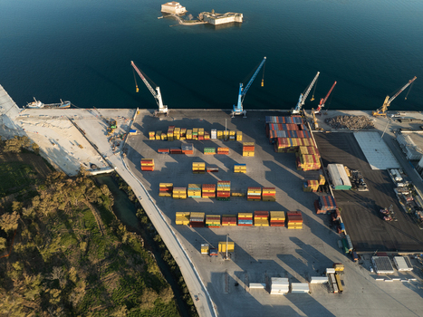 Aerial view of a container terminal with colorful shipping containers and large cranes near the sea with a historic fort in the background Augusta Sicily Italy. Aerial view of a container terminal with colorful shipping containers and large cranes near the sea with a historic fort in the background Augusta Sicily Italy.