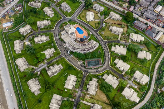 Port Harcourt Rivers Nigeria 03 July 2026 Aerial view of a residential estate with a central circular building swimming pool tennis court and houses on green lawns. Port Harcourt Rivers Nigeria 03 July 2026 Aerial view of a residential estate with a central circular building swimming pool tennis court and houses on green lawns.