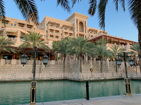View of traditional Arabic architecture with palm trees and lanterns along a turquoise water canal in Dubai Dubai United Arab Emirates. View of traditional Arabic architecture with palm trees and lanterns along a turquoise water canal in Dubai Dubai United Arab Emirates.
