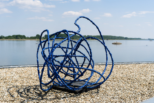 Bratislava Slovakia 09 May 2026 View of a blue abstract sculpture made of tangled lines set on a gravel path overlooking the Danube river under a clear sky.
