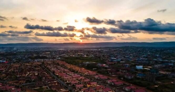 Aerial view of a residential neighborhood with rows of houses at sunset under a cloudy sky in Ghana. Aerial view of a residential neighborhood with rows of houses at sunset under a cloudy sky in Ghana.