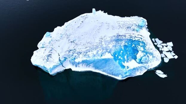 Aerial view of a large iceberg floating in the ocean Greenland. Aerial view of a large iceberg floating in the ocean Greenland.