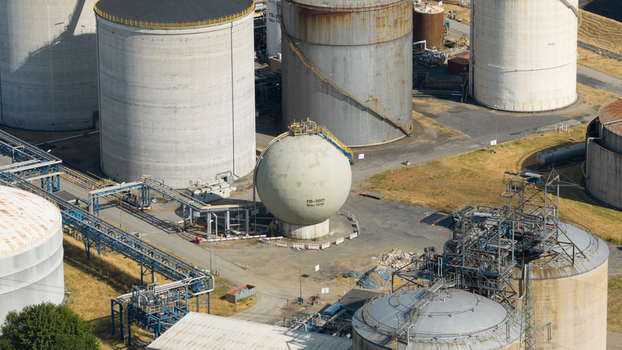 Aerial view of Tanklager featuring large industrial storage tanks and a spherical pressure vessel connected by a network of pipes in Gelsenkirchen North Rhine Westphalia Germany.