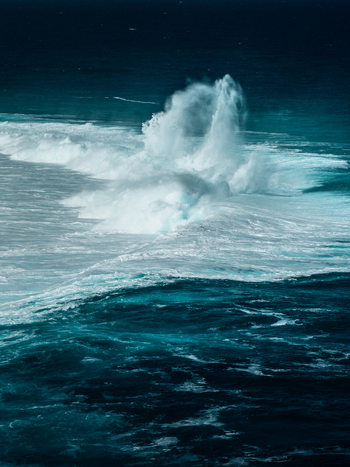 Aerial view of powerful ocean waves crashing over the coral reef with vibrant turquoise water and white sea foam in Aitutaki Cook Islands. Aerial view of powerful ocean waves crashing over the coral reef with vibrant turquoise water and white sea foam in Aitutaki Cook Islands.