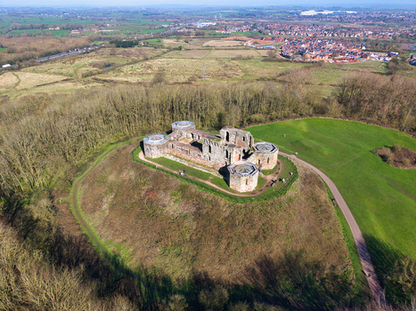 Aerial view of Stafford Castle s weathered stone ruins atop a green hill contrasting with the autumn trees and distant townscape Stafford England United Kingdom. Aerial view of Stafford Castle s weathered stone ruins atop a green hill contrasting with the autumn trees and distant townscape Stafford England United Kingdom.