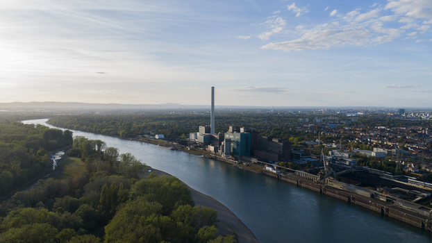 Aerial view of the Grosskraftwerk Mannheim power plant along the Rhine river with industrial infrastructure and tall chimneys in Mannheim Baden Wurttemberg Germany.