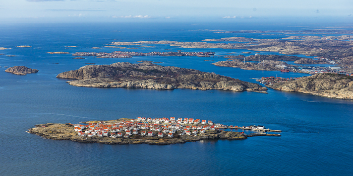 Aerial view of the island of Astol with its characteristic white houses with red roofs surrounded by the blue waters of the Skagerrak strait Astol Vastra Gotaland Sweden.