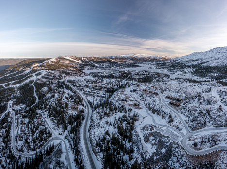 Aerial view of Gaustablikk Fjellresort surrounded by snow covered mountains winding roads and pine forests in the winter landscape of Rjukan Telemark Norway. Aerial view of Gaustablikk Fjellresort surrounded by snow covered mountains winding roads and pine forests in the winter landscape of Rjukan Telemark Norway.
