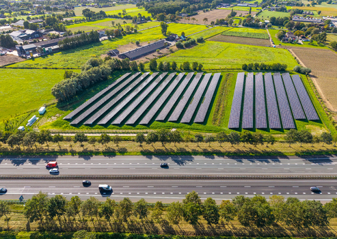 Aerial view of Solar Park with rows of photovoltaic panels and battery energy storage system next to a busy highway in Ede Gelderland Netherlands. Aerial view of Solar Park with rows of photovoltaic panels and battery energy storage system next to a busy highway in Ede Gelderland Netherlands.