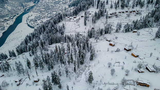 Aerial view of snow laden trees and scattered wooden houses amidst a serene wintry landscape near the river Sharda Azad Kashmir Pakistan. Aerial view of snow laden trees and scattered wooden houses amidst a serene wintry landscape near the river Sharda Azad Kashmir Pakistan.
