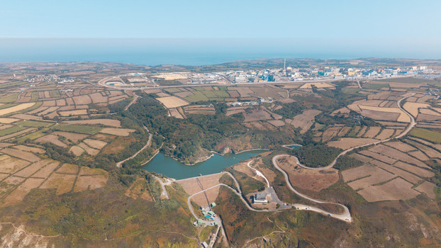 Aerial view of the reservoir and surrounding agricultural fields with the industrial facility in the distance in La Hague Normandie France.