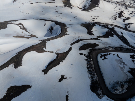 Aerial view of the snow covered volcanic landscape of Mount Etna south side with craters and winding mountain roads Nicolosi Sicilia Italy. Aerial view of the snow covered volcanic landscape of Mount Etna south side with craters and winding mountain roads Nicolosi Sicilia Italy.