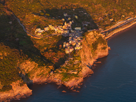 Aerial view of the historic village of Corniglia perched on a rocky cliff overlooking the sea during golden hour Corniglia Liguria Italy. Aerial view of the historic village of Corniglia perched on a rocky cliff overlooking the sea during golden hour Corniglia Liguria Italy.