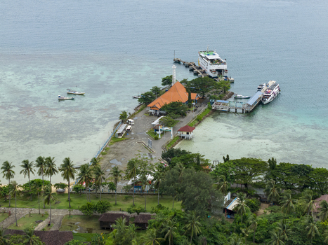 Aerial view of the karimunjawa ferry terminal with the red rooftops nestled between the boats and the turquoise sea Karimunjawa Jawa Tengah Indonesia. Aerial view of the karimunjawa ferry terminal with the red rooftops nestled between the boats and the turquoise sea Karimunjawa Jawa Tengah Indonesia.