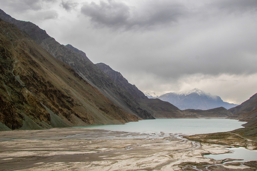 View of Satpara Dam and its turquoise waters surrounded by steep barren mountains under a cloudy sky in Skardu Gilgit Pakistan. View of Satpara Dam and its turquoise waters surrounded by steep barren mountains under a cloudy sky in Skardu Gilgit Pakistan.