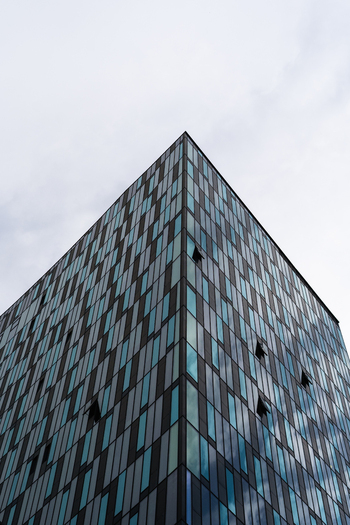 View of a modern skyscraper with a glass facade and open windows under an overcast sky in Vienna Vienna Austria. View of a modern skyscraper with a glass facade and open windows under an overcast sky in Vienna Vienna Austria.
