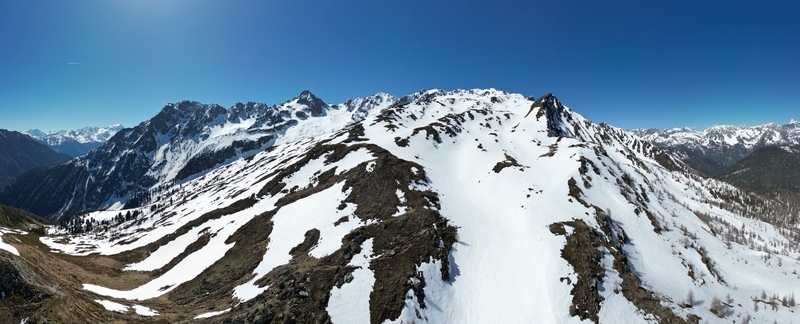 Aerial view of Pointe Ronde mountain peak covered in snow with rugged ridges and alpine slopes under a clear blue sky in the Swiss Alps near Trient Valais Switzerland.
