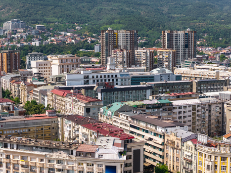 Aerial view of the dense urban landscape of Skopje with residential apartment buildings historic architecture and mountains in the background in Skopje Greater Skopje North Macedonia. Aerial view of the dense urban landscape of Skopje with residential apartment buildings historic architecture and mountains in the background in Skopje Greater Skopje North Macedonia.