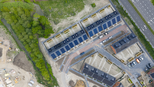 Aerial view of modern residential houses with solar panels on roofs next to a green area and a stream in Utrecht Utrecht Netherlands.
