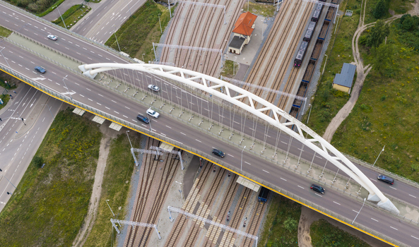 Aerial view of a modern cable stayed bridge spanning over railway tracks with cars driving on the road and trains parked below in Gdansk Pomeranian Voivodeship Poland. Aerial view of a modern cable stayed bridge spanning over railway tracks with cars driving on the road and trains parked below in Gdansk Pomeranian Voivodeship Poland.