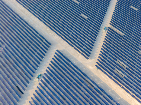 Aerial view of a vast solar farm featuring rows of blue photovoltaic panels and sandy access paths in the desert Enterprise Nevada United States. Aerial view of a vast solar farm featuring rows of blue photovoltaic panels and sandy access paths in the desert Enterprise Nevada United States.
