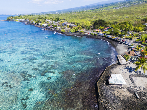 Aerial view of Kahalu u Beach Park featuring turquoise waters vibrant coral reefs and a rocky shoreline under a clear blue sky in Kailua Kona Hawaii United States. Aerial view of Kahalu u Beach Park featuring turquoise waters vibrant coral reefs and a rocky shoreline under a clear blue sky in Kailua Kona Hawaii United States.