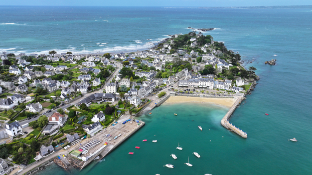 Aerial view of the coastal town of Locquirec with its harbor sandy beach and traditional houses on a peninsula Locquirec Brittany France. Aerial view of the coastal town of Locquirec with its harbor sandy beach and traditional houses on a peninsula Locquirec Brittany France.