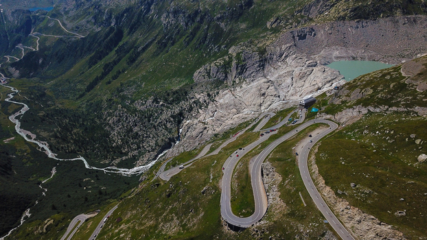 Aerial view of the winding roads of the Furka Pass near the Rhone Glacier and a turquoise mountain lake in Obergoms Valais Switzerland. Aerial view of the winding roads of the Furka Pass near the Rhone Glacier and a turquoise mountain lake in Obergoms Valais Switzerland.