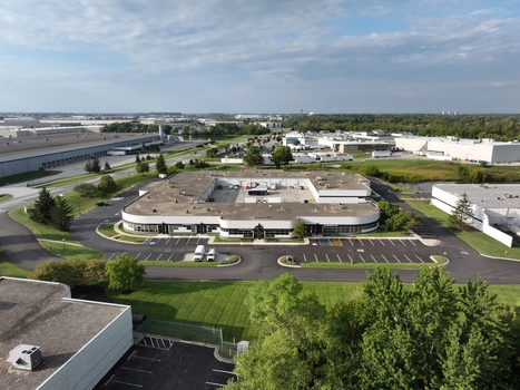 Aerial view of a modern commercial office building with a central courtyard surrounded by parking lots green lawns and industrial warehouses in Indianapolis Indiana United States. Aerial view of a modern commercial office building with a central courtyard surrounded by parking lots green lawns and industrial warehouses in Indianapolis Indiana United States.