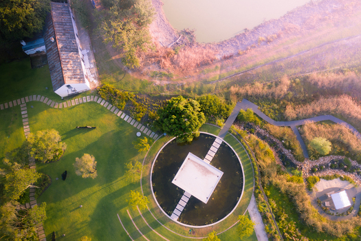 Aerial view of a modern pavilion in a circular pond surrounded by lush green lawns and stone pathways in Cape Town Western Cape South Africa. Aerial view of a modern pavilion in a circular pond surrounded by lush green lawns and stone pathways in Cape Town Western Cape South Africa.