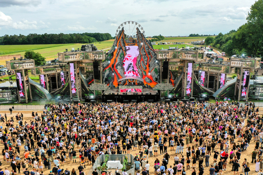 Herzogenaurach Germany 27 July 2025 Aerial view of Open Beatz Festival main stage with a volcano theme large crowd of people and a Ferris wheel under a cloudy sky. Herzogenaurach Germany 27 July 2025 Aerial view of Open Beatz Festival main stage with a volcano theme large crowd of people and a Ferris wheel under a cloudy sky.