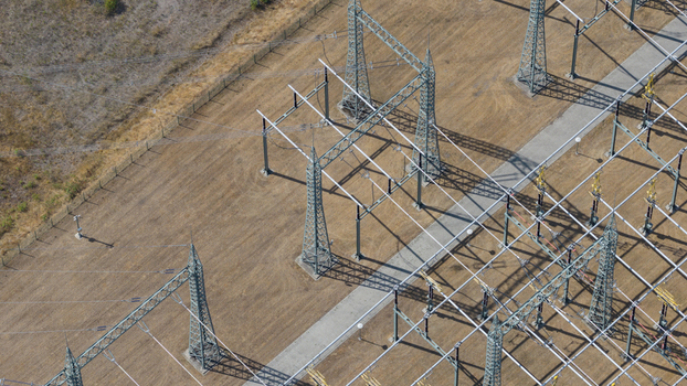 Aerial view of the Amprion Gmbh electrical substation featuring high voltage transmission towers and power lines across a dry field in Herten Nordrhein Westfalen Germany.