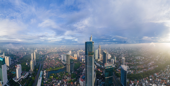 South Jakarta Indonesia 10 January 2026 Aerial view of the Autograph Tower and modern skyscrapers in the Thamrin Nine district under a hazy blue sky at sunset. South Jakarta Indonesia 10 January 2026 Aerial view of the Autograph Tower and modern skyscrapers in the Thamrin Nine district under a hazy blue sky at sunset.