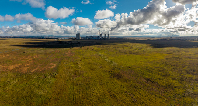 Aerial view of a coal fired power station with cooling towers and chimneys across vast grasslands under a cloudy sky in Vaal Power Small Holdings Free State South Africa. Aerial view of a coal fired power station with cooling towers and chimneys across vast grasslands under a cloudy sky in Vaal Power Small Holdings Free State South Africa.