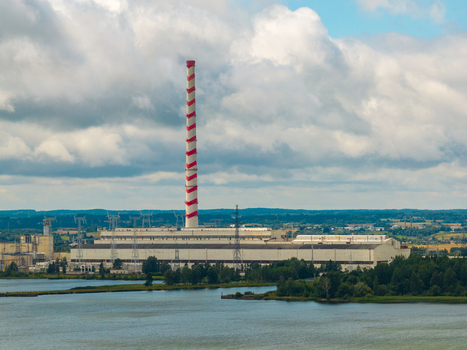 Aerial view of the Elektrenai Power Plant with its red and white striped chimney industrial buildings and electrical infrastructure near a lake in Elektrenai Vilnius County Lithuania. Aerial view of the Elektrenai Power Plant with its red and white striped chimney industrial buildings and electrical infrastructure near a lake in Elektrenai Vilnius County Lithuania.