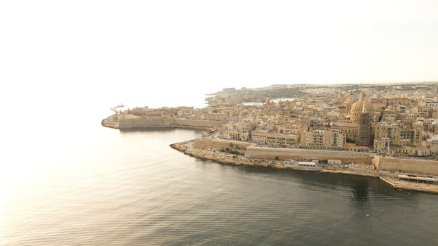 Aerial view of the historic city of Valletta with its limestone buildings the prominent dome of the Basilica of Our Lady of Mount Carmel and fortifications overlooking the sea in Malta. Aerial view of the historic city of Valletta with its limestone buildings the prominent dome of the Basilica of Our Lady of Mount Carmel and fortifications overlooking the sea in Malta.