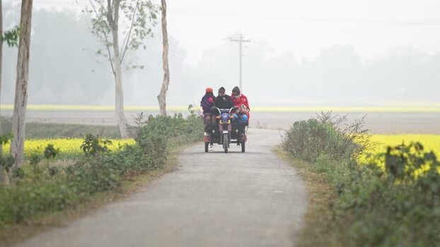 View of people on a motorized tricycle in Bogura Bangladesh. View of people on a motorized tricycle in Bogura Bangladesh.