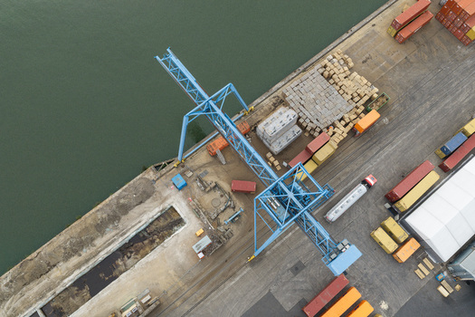 Aerial view of the Haven Genk container terminal with a large blue port crane colorful shipping containers and industrial logistics infrastructure in Genk Vlaanderen Belgium.